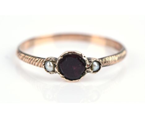Georgian garnet and pearl ring, with central round cut garnet flanked either side by a seed pearl, in a closed back setting, 