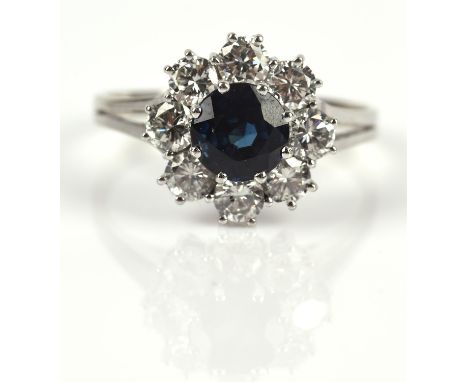 1970's Sapphire and diamond cluster ring, with central round cut sapphire weighing an estimated 1.24 carats, with a surround 