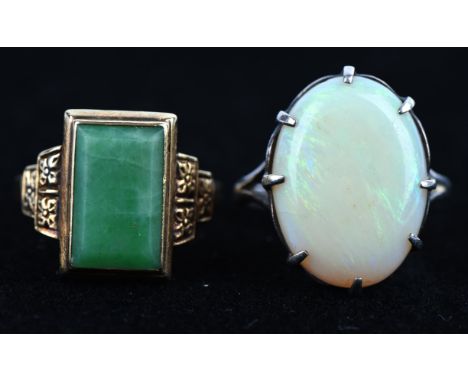 Two rings, including an jade ring with a tablet of jade, in 9 ct, size K½, and a silver ring set with an oval cabochon opal, 