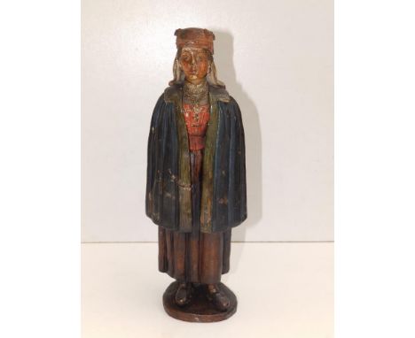 An old painted terracotta figure depicting a young female wearing a clock and cross,  10.5" high = a/f