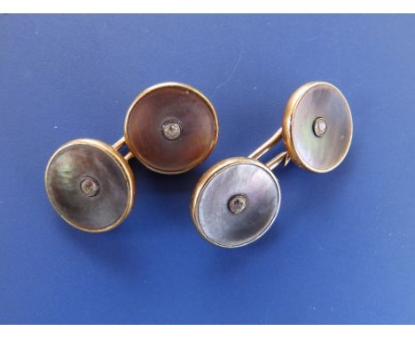 A pair of 18ct gold  circular cufflinks, each set with a small diamond in mother-of-pearl. (2)