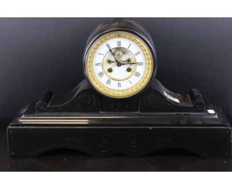 A black slate mantle clock with scrolling decoration, complete with key. 
