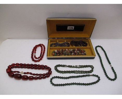 A selection of necklaces to include a cherry red graduated bead necklace, a smaller cherry red phenolic amber faceted and gra