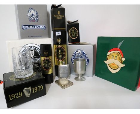 A collection of Guinness boxed commemorative items to include a cut glass tankard and a hip flask