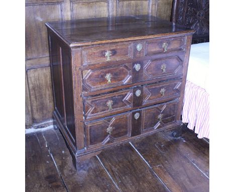 A 17th Century and later oak chest, the plank top with applied moulded edge over four long drawers with applied mouldings and