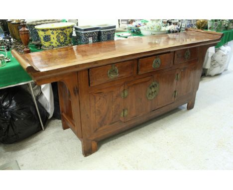 A Chinese hardwood side cabinet the plain top with scroll ends over three drawers and two cupboard doors on style supports, 2