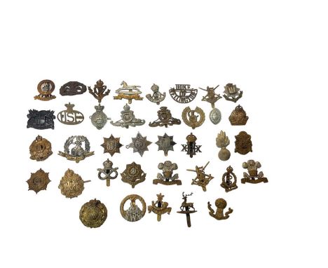 Collection of military cap badges including Norfolk Regiment, Royal Artillery, Durham Light Infantry and others.