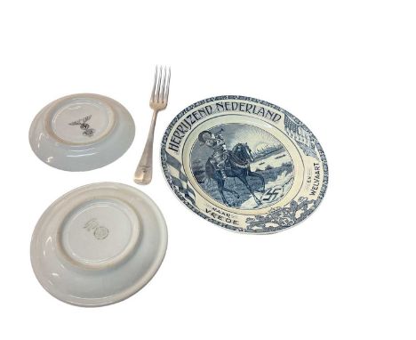 Two Nazi porcelain saucers, together with a Luftwaffe fork and a Dutch blue and white anti Nazi plate