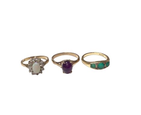 Three gold rings to include an 18ct gold three stone jade/green stone ring, size L½, 9ct gold amethyst cabochon ring, size O 