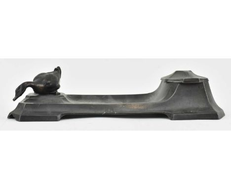 An early 20th century Art Deco spelter inkwell after Archibald Knox. The ink well featuring central pen rest, lidded ink well