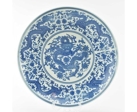 An early 20th century Chinese blue and white ceramic charger plate. The circular charger decorated with dragon to centre and 