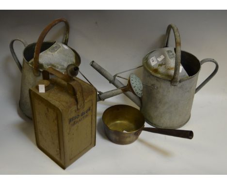 A pair of galvanized watering cans; a brass jam pan; an Esso Blue Parafin can 