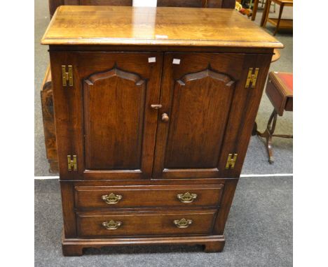 A Titchmarsh & Goodwin oak television cabinet, shield shaped panels doors above two long graduating drawers, bracket feet, H-