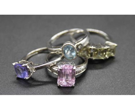 Four various modern 9ct white gold precious and semi precious set dress rings, to include blue topaz and tanzanite set exampl