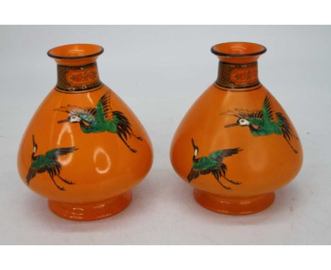 A pair of 1930s Shelley vases, each on a orange ground, printed and enamel decorated with birds in flight having printed Shel