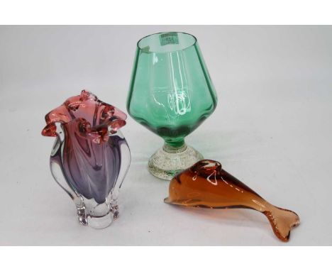 A modern pink tinted art glass vase together with an oversized brandy glass and a figure of a dolphin