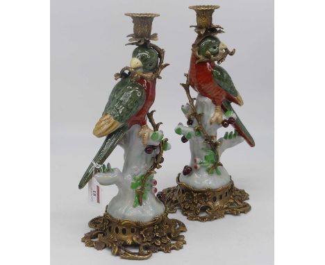A pair of continental porcelain and gilt metal table candlesticks, each in the form of a parrot perched upon a stump, height 