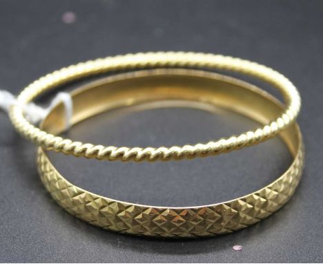An 18ct gold bangle, having bright cut decoration; together with an unmarked yellow metal ropetwist bangle, tests as approx 1