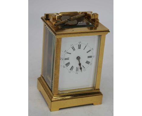 A lacquered brass cased carriage clock having enamel dial with Roman numerals and Arabic outer scale with visible platform es