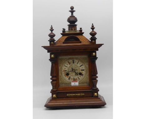 An early 20th century walnut cased eight day mantel clock, the dial showing Roman numerals, height 45cm