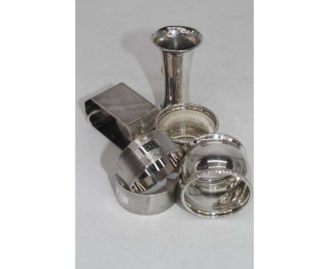 A George VI silver napkin ring, of octagonal form with engine turned decoration; together with two pairs of silver napkin rin