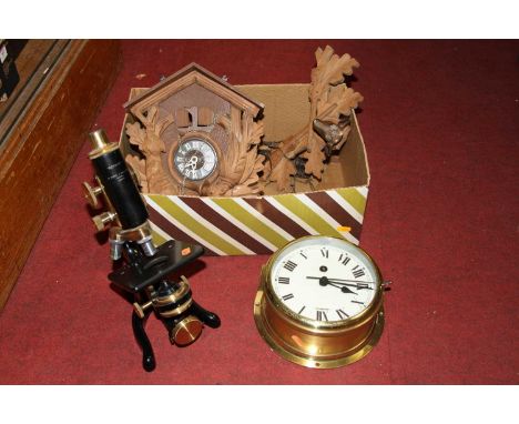 A Watson &amp; Sons monocular microscope; together with a Swiss cuckoo clock and a brass cased ships clock (3)