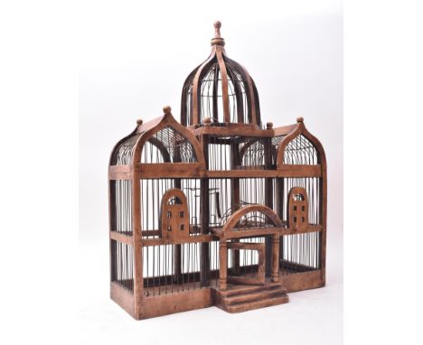 A 20th century Victorian style varnish wood architectural birdcage. The bird cage having three finial top tower sections over