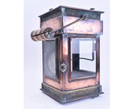 An early 20th century copper and iron handheld yard / railway lantern lamp. The lamp with a pine handle and square in form, w