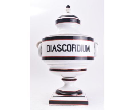 A 20th century ceramic shop display ' Diascordium ' apothecary urn vase. The urn having a lid with finial atop (af) over a fl