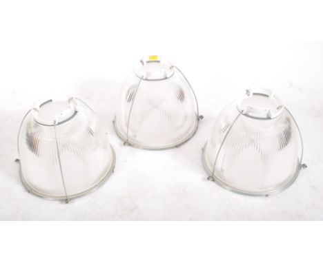 A matching set of three contemporary Holophane industrial factory pendant light shades of metal and glass construction having