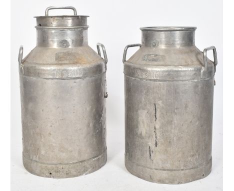 A pair of vintage 20th century aluminium milk churns marked Nestle. Each churn with twin handles to each sides, embossed in r