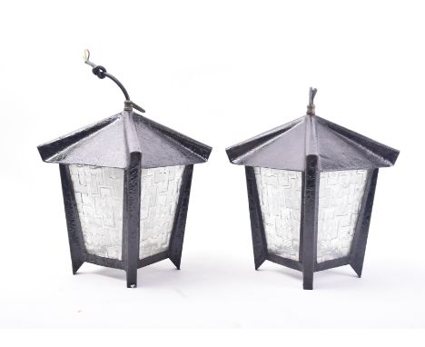 A pair of vintage 20th century French porch lantern lights. Each lamp hanging from the ceiling with arched tops and textured 