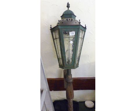 CAST METAL LIGHT. Lead glazed cast metal electric light on  carved wooden support