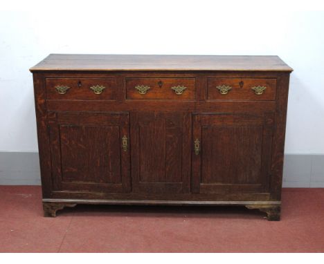 A Late XVIII Century Joined Oak Dresser Base, with three top drawers and central arched panel flanking cupboard doors, on bra