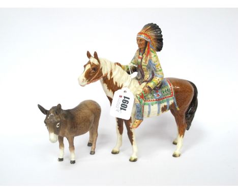 A Beswick Pottery Figure of a 'Mounted Red Indian', model No 1391, printed marks, 22cm high; A Beswick Model of a Donkey, 11c