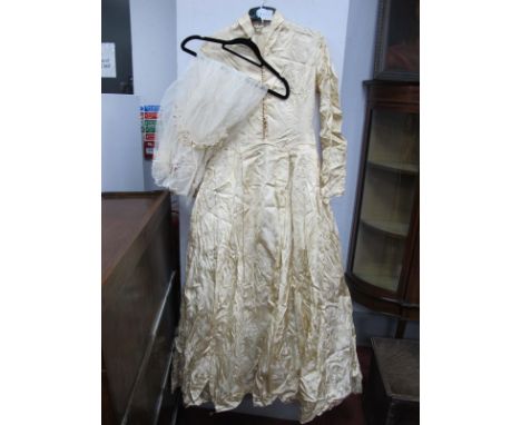 A Mid XX Century Cream Brocade Wedding Gown, with fitted bodice fastened to the front with pearl button and  rouleau loops, w