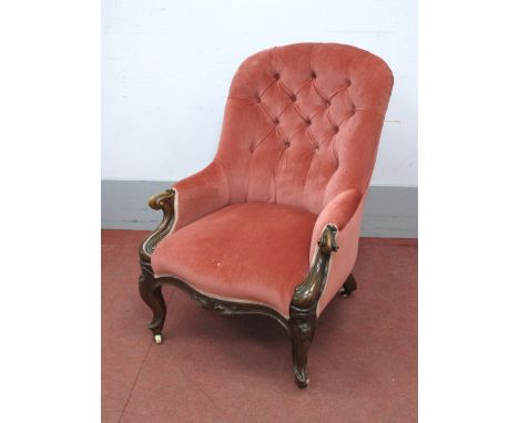 A Mid XIX Century Walnut Armchair, with upholstered button back, scroll arms and shaped apron on cabriole legs.