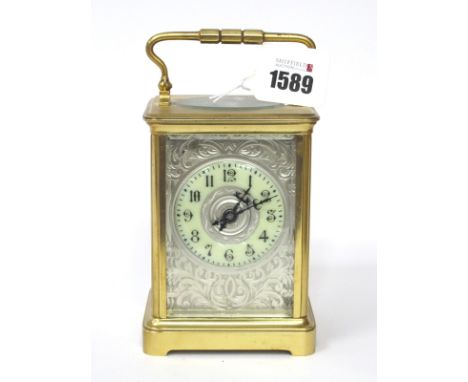 An Early XX Century Brass Cased Carriage Clock, of typical form, the silver engraved dial with cream chapter ring with Arabic