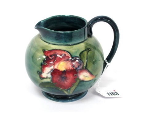 A Moorcroft Pottery Jug, painted in the 'Orchid' pattern against a shaded green/blue ground, impressed marks, 14cm high.Lot 1