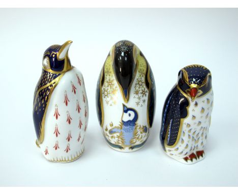 Three Royal Crown Derby Porcelain Paperweights; 'Penguin and Chick', 'Penguin' and 'Rock Hopper Penguin', all gold stoppers, 