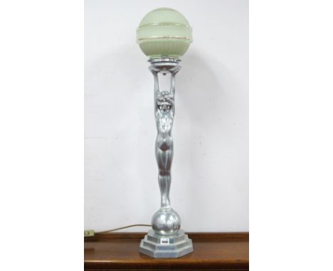 An Art Deco Style Chromed Table Lamp, modelled in the form of a naked lady, her arms held high to hold the part frosted green