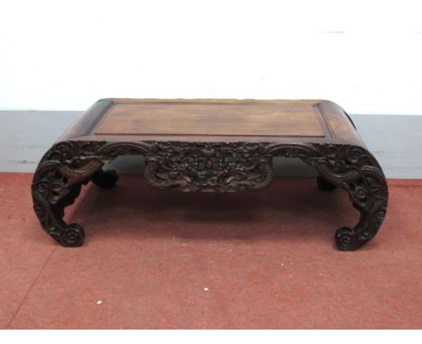 A Late XIX/Early XX Century Chinese Hardwood Opium Table, with panelled top and carved frieze, shaped sides and scroll feet, 