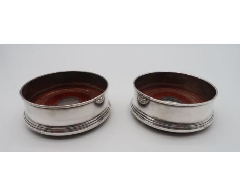 A pair of Elizabeth II silver wine coasters, by&nbsp;W I Broadway &amp; Co, Birmingham 1998, with a turned wooden insert and 