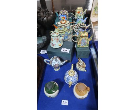 A collection of Trade + Aid enamel miniature teapots and two miniature ceramic whisky flagons Condition Report:No condition r