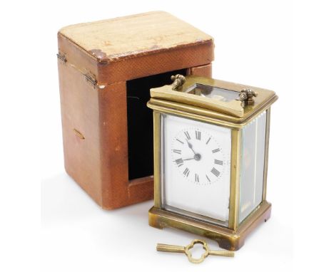 An early 20thC brass cased carriage clock, with an eight day French movement, a white enamelled face, in a red leather travel