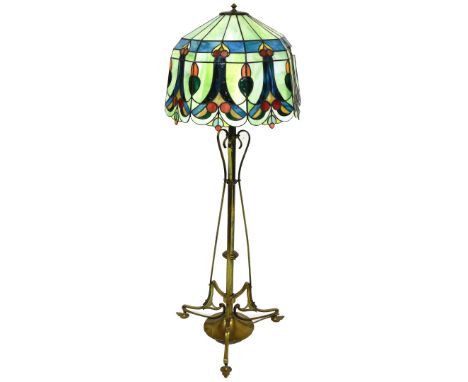 An Art Nouveau brass metamorphic lamp standard, the cylindrical stem held by swan necked supports, on a circular foot termina