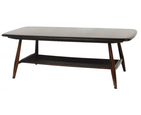 A 20thC Ercol coffee table, on turned legs joined by a newspaper rack beneath, with Hunters label, 36cm high, 104cm wide, 45c