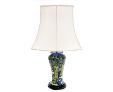 A Moorcroft table lamp, depicting trees and flowers, on a mahogany base, numbered to underside ST62BHX, with shade, 37cm high