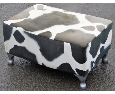 A cow print foot stool, upholstered in velvet cow print material, on silvered feet (AF), 31cm high, 59cm wide, 39cm deep.