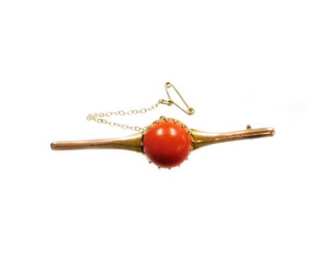 A 9ct gold coral set bar brooch, the large circular coral cabochon in a claw setting, 1.6mm wide, 9.2mm deep, the coral with 